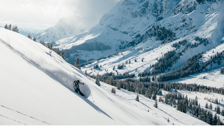 Rider avec un système Scott Alpride activé sur la piste de ski à côté de ses skis