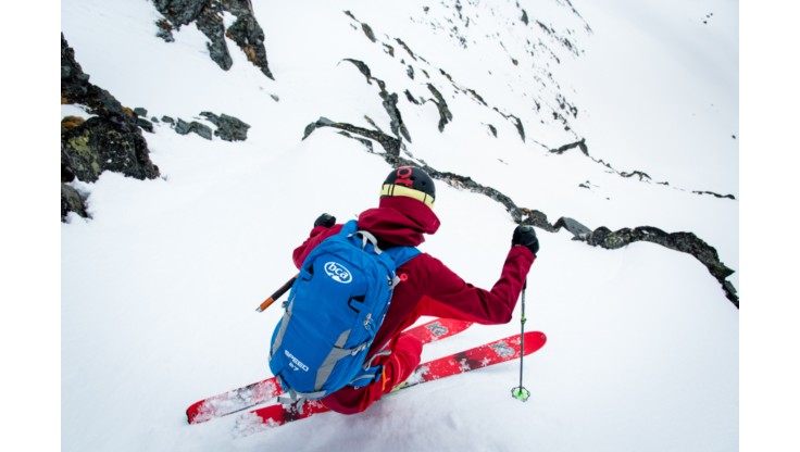 Freeride skiløber står ned af bjerget med en lavinerygsæk fra Float