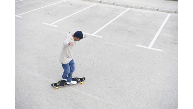 Young man riding his longboard