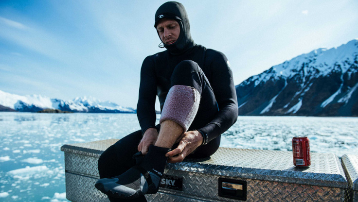 Professional surfer Mick Fanning putting on surf booties in Alaska
