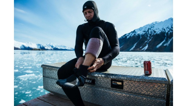 Il surfer professionista Mick Fanning indossa stivaletti prima di una sessione di surf in Alaska