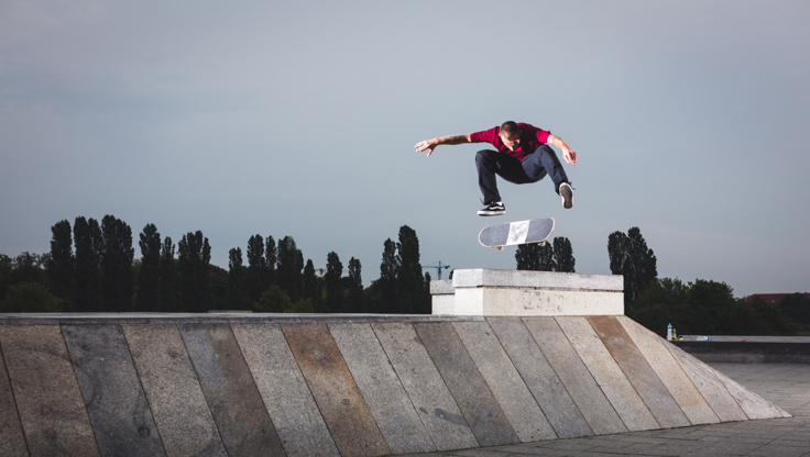 Uno skateboarder esegue un kickflip nello skatepark