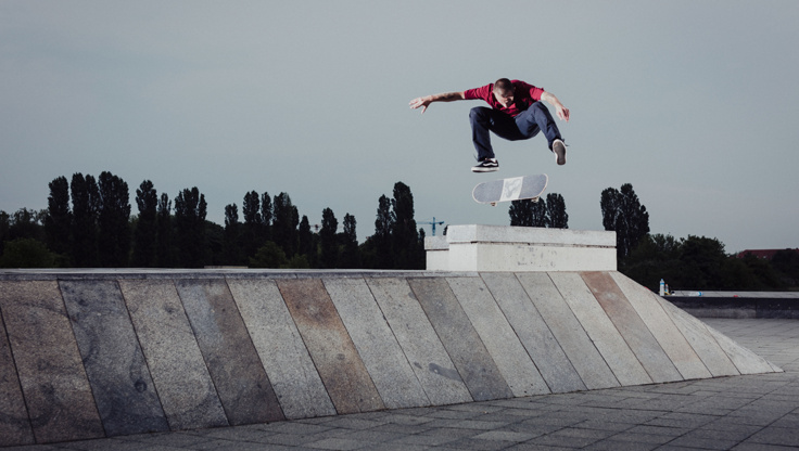 Uno skateboarder esegue un kickflip nello skatepark
