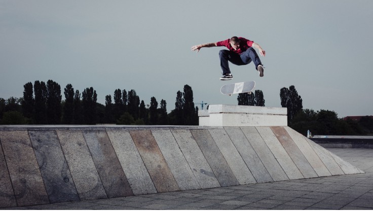 Skateboardkjører som gjør et kickflip i skateparken