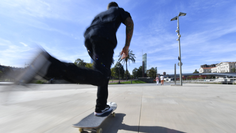 Mit hoher Geschwindigkeit auf dem Skateboard in Spanien fahren. Ein Fuß steht sicher auf dem Board.