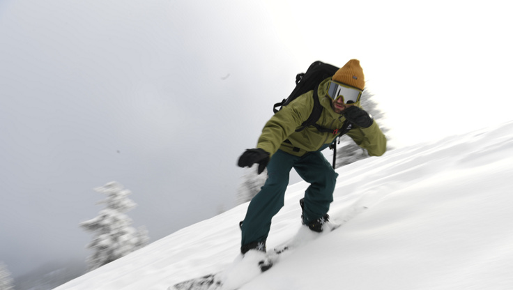 Freeride-Snowboarder auf einem steilen Berg