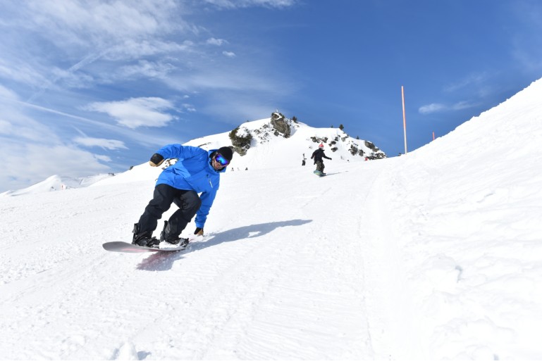 Blue Tomato teacher tail sliding on snowboard