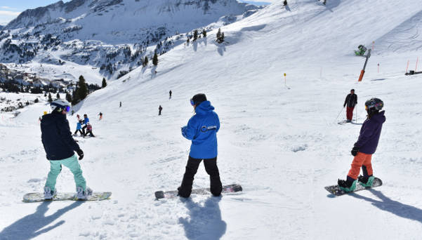 Snowboardlehrer erklärt den Schülern die nächste Übung