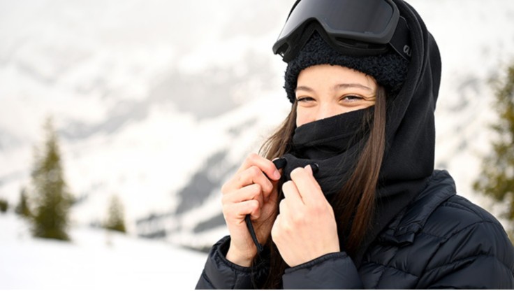 Manlig snowboardåkare utomhus med ansiktet helt täckt med bandana och goggle