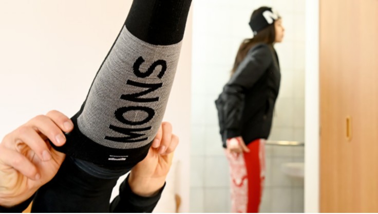 Mädchen in Funktionsunterwäsche von Mons Royal zieht sich Funktions-Socken an
