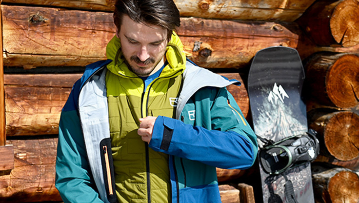 Snowboarder shows different layers of his functional clothing