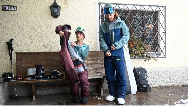 Snowboardåkare visar olika lager av sina funktionella kläder
