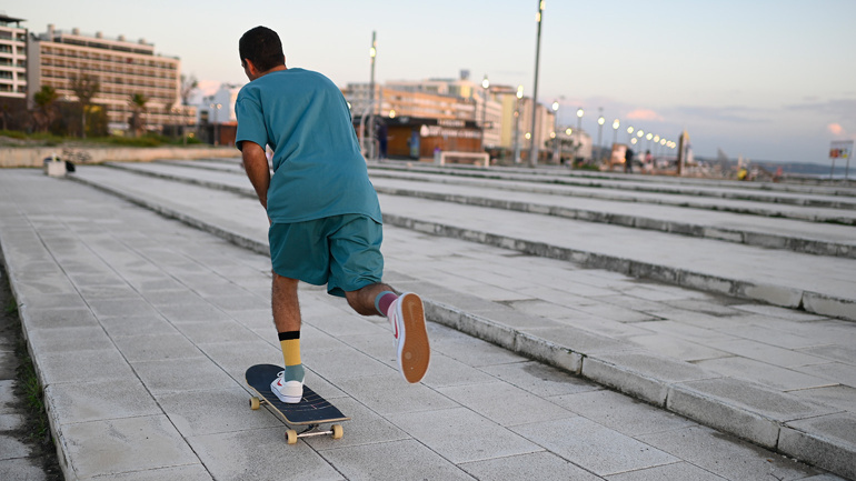 Står på skateboard i Spanien med en fod sikker på boardet