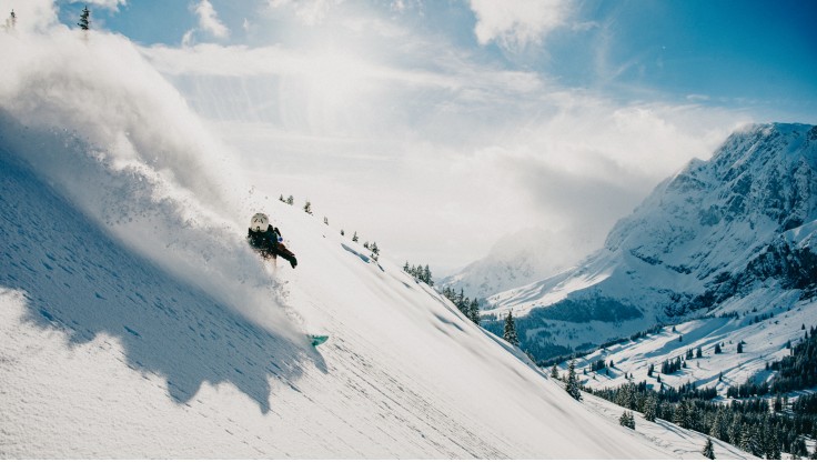 Snowboarder freeride su una montagna ripida