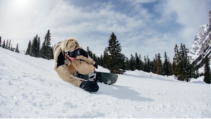 Snowboarder carved on the slope with hard binding