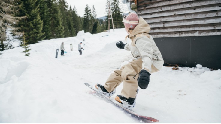 en mand og en kvinde lærer at snowboarde