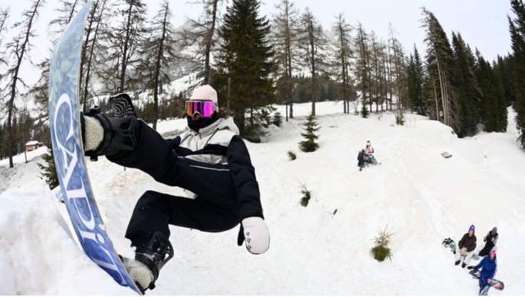 Un snowboarder hace trucos en la pista