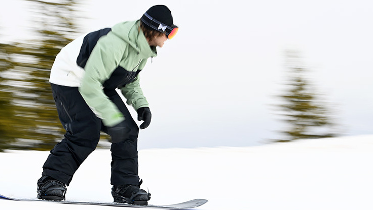 Ein Snowboarder springt abseits der Piste in unberührten Neuschnee