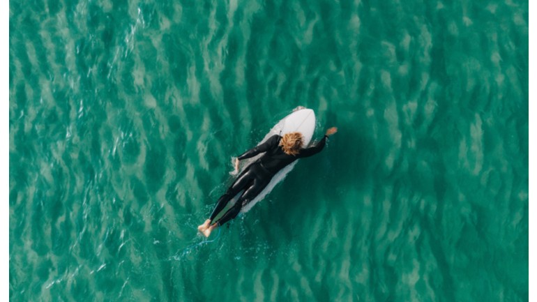 Drei Surfer warten auf die nächste Welle